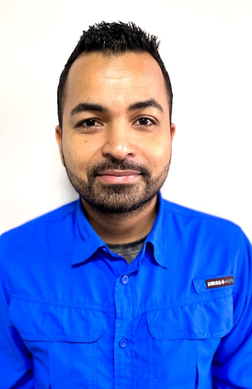 Man with short dark hair and a beard in a blue button-down shirt